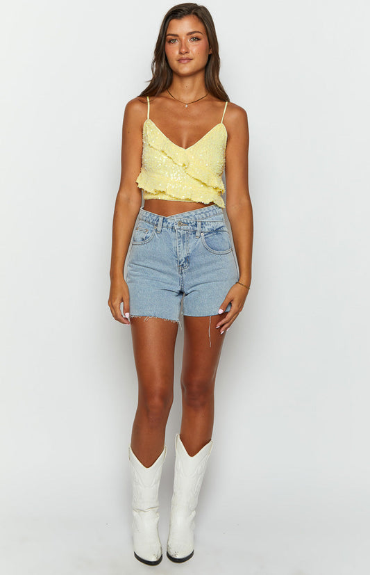 sparkly yellow sequin top with frills and thin straps on brunette model