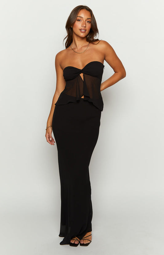 Full length view of a black maxi skirt with a fitted high waist and flowing silhouette