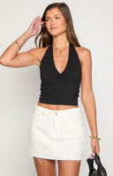 blonde girl wearing a lack halter tank top paired with white jeans