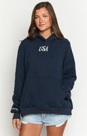 Girl wearing a navy sweatshirt with a red and blue embroidered flag on the back, paired with red and white striped shorts