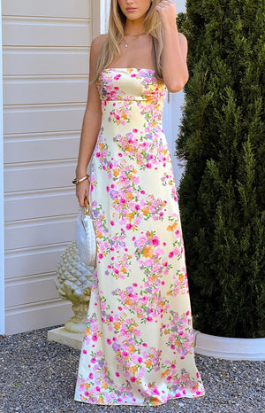 A beautiful pale yellow satin maxi dress adorned with pink and orange floral blooms, designed in a sleek silhouette, perfect for a summer formal or garden party.