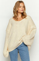 Cream chunky knit sweater with an off-shoulder neckline, oversized fit, and voluminous long sleeves