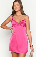 Girl wearing a fitted hot pink mini dress, showing its sleek silhouette. This semi-formal dress has a gathered sweetheart bust and a simple, elegant A-line cut.
