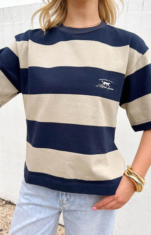 blonde model wearing a boxy t shirt with a blue and beige stripe design