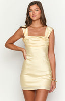 blonde girl wearing a yellow open back mini semi formal dress with gold jewellery