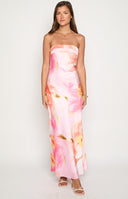 blonde model wearing a pink floral print satin formal gown with orange yellow and green flower details