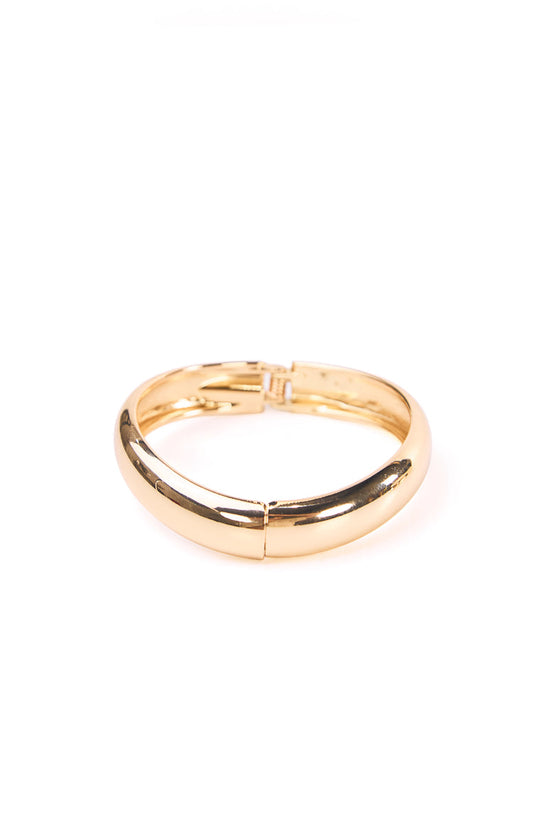 A polished gold bangle with a secure clasp mechanism. This versatile accessory can be worn with a casual daytime look or an evening party dress. A lovely gift for a birthday or anniversary.