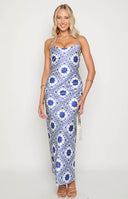 White maxi dress with blue print across fabric and thin straps, with brown bag and brown shoes on blonde model
