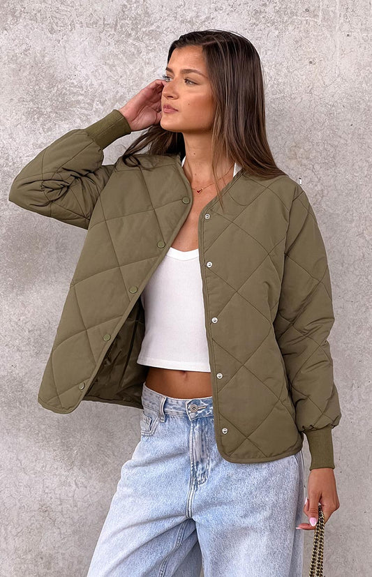 model is wearing a khaki quilted bomber jacket paired with a white tank and light wash denim jeans