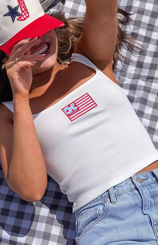 Model wearing a white sleeveless tank top with a red and blue patch graphic on the front