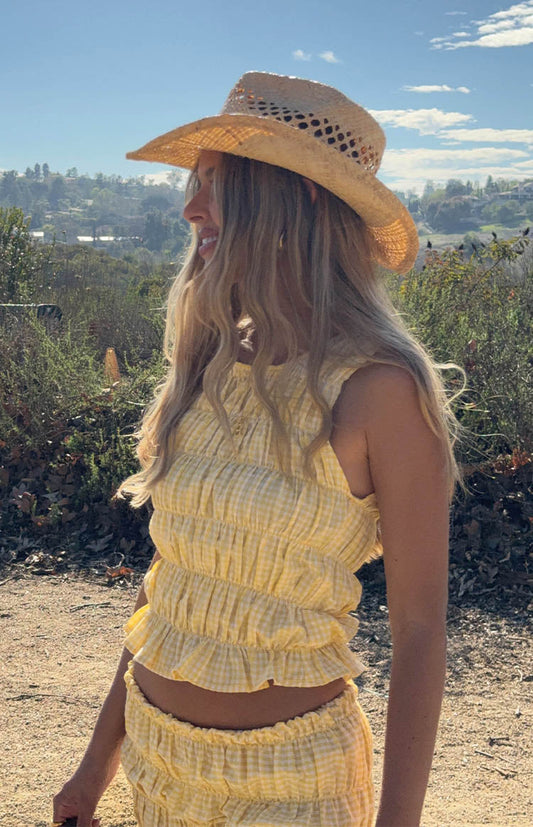 model wearing a yellow gingham sleeveless top with ruched and ruffle details 