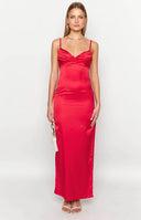 Brunette model wearing a red maxi dress and clear heels outdoors.
